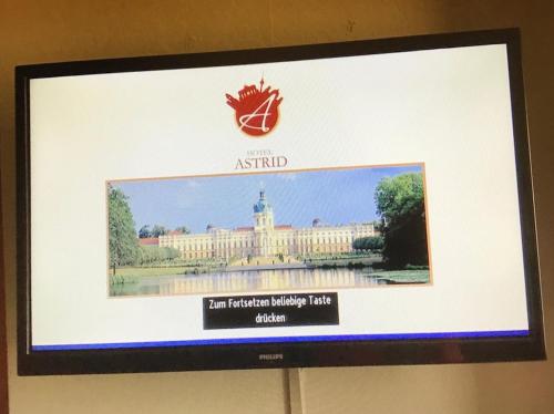 a television screen with a picture of a building at Hotel Astrid am Kurfürstendamm in Berlin