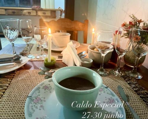 una mesa con una taza de café en un plato en Pouso das Flores -350m Maria Fumaça, en Tiradentes