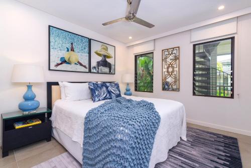 a bedroom with a bed and a ceiling fan at The Posh Penthouse With Stunning Rooftop Oasis, Free Parking And WIFI in Port Douglas
