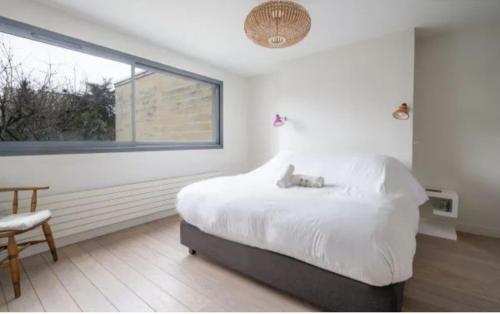 une chambre blanche avec un lit et une fenêtre dans l'établissement Parc Saint James, à Neuilly-sur-Seine