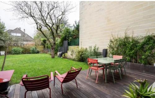 d'une terrasse avec une table, des chaises et une pelouse. dans l'établissement Parc Saint James, à Neuilly-sur-Seine