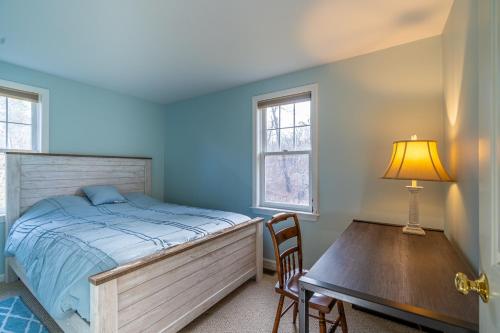 a bedroom with a bed and a table with a lamp at Cozy Cape Classic-Central AC&Near Bay Beaches in Barnstable