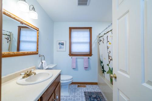 a bathroom with a sink and a toilet and a mirror at Cozy Cape Classic-Central AC&Near Bay Beaches in Barnstable