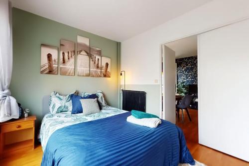 a bedroom with a bed with a blue comforter at Proche Disney & Paris-2 min gare in Noisy-le-Grand