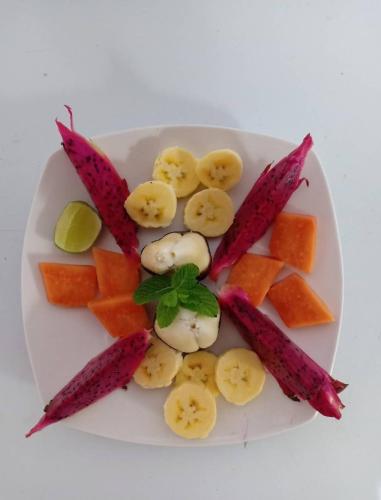 a plate of fruit and vegetables on a white plate at Maskot Penida Cottage in Nusa Penida