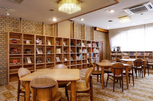 biblioteca con mesas, sillas y estanterías en Hotel OBANA en Nara