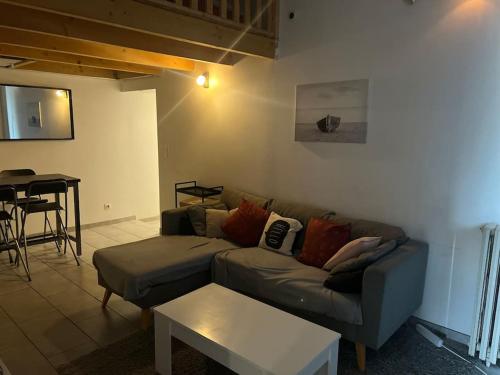 un salon avec un canapé et une table dans l'établissement Maison Téranga 2 Chambres Et 2 mezzanines et 2 parking gratuits, à Courrejean