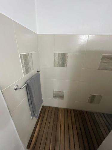 a bathroom with a shower with a wooden floor at View Haven Villa in Jolly Harbour