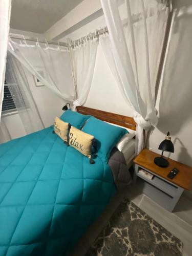 um quarto com uma cama azul e uma janela em View Haven Villa em Jolly Harbour