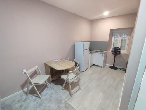 une cuisine avec une table, des chaises et un réfrigérateur dans l'établissement Apartman Matej, à Trebinje