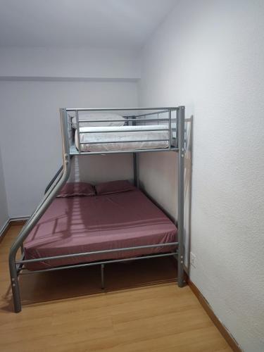 ein kleines Metall-Etagenbett in einem Zimmer in der Unterkunft Sencillo Alcala in Alcalá de Henares