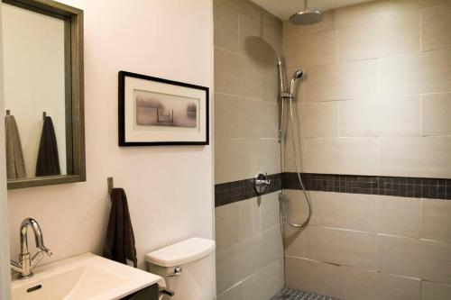 a bathroom with a shower and a toilet and a sink at Woodbine Warehouse Apartment in Toronto
