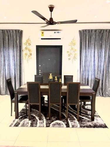 een eetkamer met een tafel en stoelen en een plafondventilator bij Executive Home away from Home in Accra
