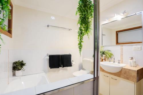 a bathroom with white walls and a sink and a mirror at Damia 1 Hideaway Agnes Water in Agnes Water