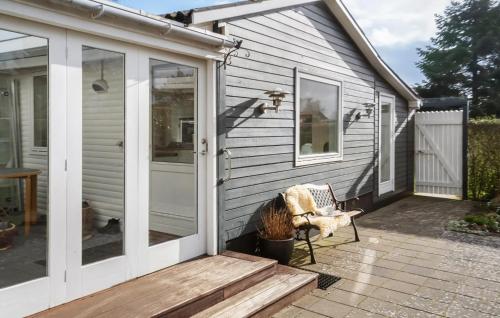 a screened in porch with a chair on a patio at 3 Bedroom Beautiful Home In Juelsminde in Juelsminde