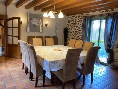 une salle à manger avec une table et des chaises dans l'établissement Gîte de charme avec SPA et cheminée, près du Mans, 7 chambres, WIFI, en bord de forêt de Vibraye - FR-1-410-308, à Dollon
