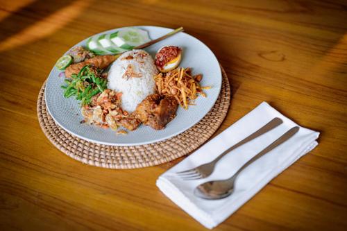 a plate of food on a table with a fork at Kaloka Airport Hotel in Labu Sumbawa