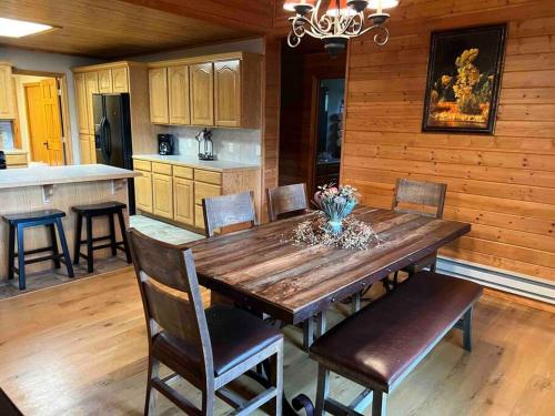 cocina y comedor con mesa de madera y sillas en Cabin on the Green, en Thayne