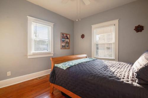 1 dormitorio con 1 cama y 2 ventanas en Charming 2BR Getaway en New Albany