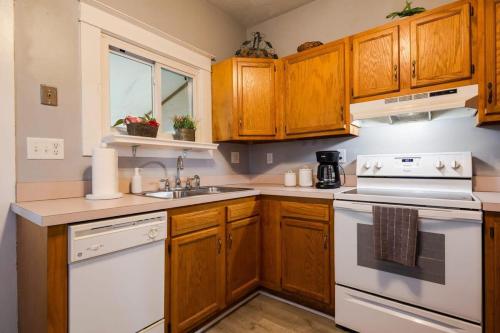 a kitchen with wooden cabinets and white appliances at Charming 2BR Getaway in New Albany