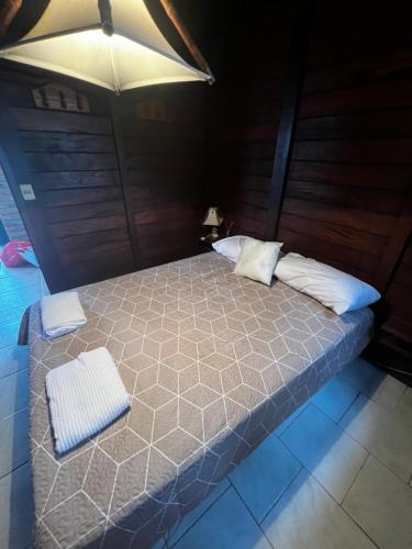 Cabañas en Parque Aqua Park في Juan L. Lacaze: سرير عليه وسادتين في غرفة