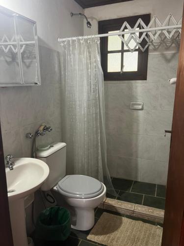 a bathroom with a toilet and a shower and a sink at Cabañas en Parque Aqua Park in Juan L. Lacaze