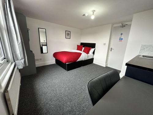 1 dormitorio con 1 cama con almohadas rojas en Premier Nottingham Studios - Gawthorne en Nottingham