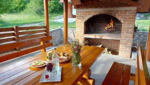 a picnic table with a brick fireplace on a patio at Family friendly house with a parking space Otocac, Velebit - 20654 in Otočac
