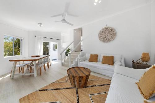 a white living room with a table and a couch at (HA2)BEACH VIBES Sunshine beach,100m to Beach, in Sunshine Beach