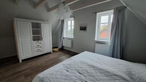 een slaapkamer met een wit bed en een raam bij Möwen-Nest in Tönning
