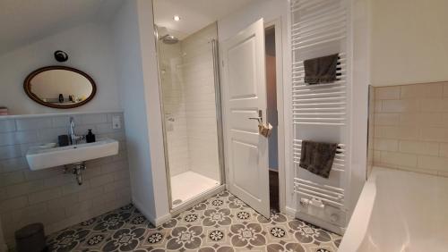 een witte badkamer met een douche en een wastafel bij Möwen-Nest in Tönning