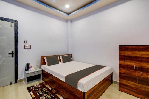 a small bedroom with a bed and a dresser at Super Collection O Ashirbad Lodge in Guwahati