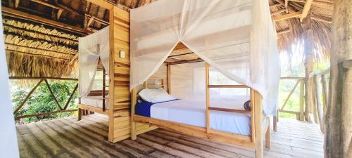 a bedroom with two bunk beds in a tree house at Encanto Hostel in Guachaca