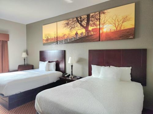 a hotel room with two beds and a painting on the wall at Days Inn by Wyndham Kemah in Kemah