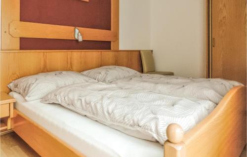 uma cama não feita num quarto com uma cabeceira em madeira em Beautiful Apartment In Mhlbach Am Hochknig With Kitchen em Mühlbach am Hochkönig