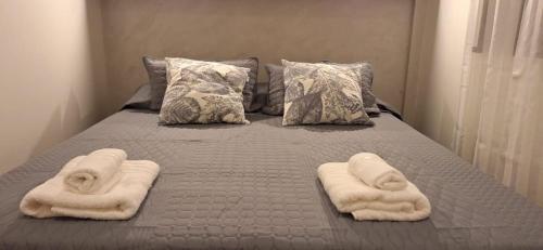 a bed with towels and pillows on it at Baireshistorico in Buenos Aires