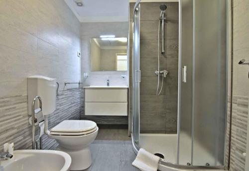 y baño con ducha, aseo y lavamanos. en Apartments for families with children Sosi, Umag - 22546, en Umag