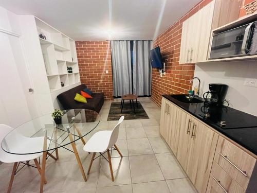 cocina y sala de estar con mesa de cristal y sillas en Apartamento zona 4, Ciudad de Guatemala en Guatemala