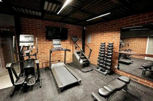 a gym with cardio equipment and a brick wall at Apartamento zona 4, Ciudad de Guatemala in Guatemala