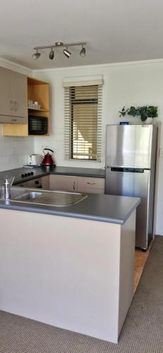 a kitchen with a white counter and a refrigerator at The Atrium in Mount Maunganui