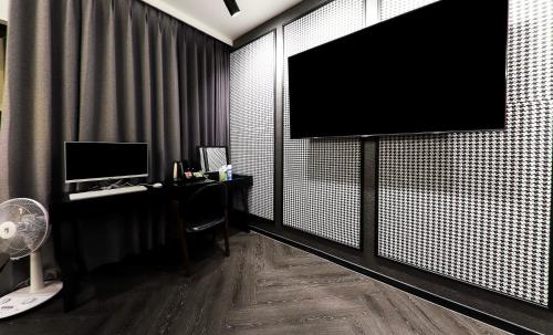 a room with a monitor on a wall with a desk at Den Basta hotel in Yangsan