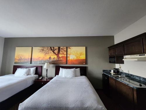 a hotel room with two beds and a painting on the wall at Days Inn by Wyndham Kemah in Kemah