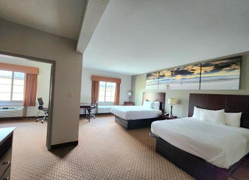 a large hotel room with two beds and a desk at Days Inn by Wyndham Kemah in Kemah