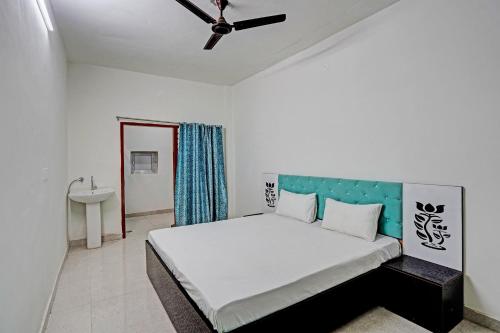 1 dormitorio con 1 cama grande y ventilador de techo en Super OYO Chawla's Hotel & Restaurant, en Gurgaon