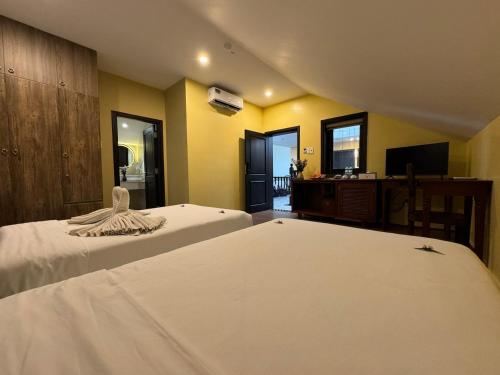 a hotel room with two beds and a television at Hoianan Boutique Hotel in Hoi An