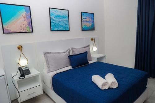 a bedroom with a blue bed with two white pillows at JOMYS HOTEL en Higüey in Higuey