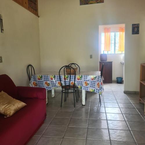 sala de estar con mesa, sillas y sofá en Casa de veraneio, en Ilha Comprida