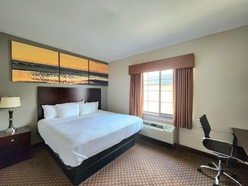 a hotel room with a large bed and a window at Days Inn by Wyndham Kemah in Kemah