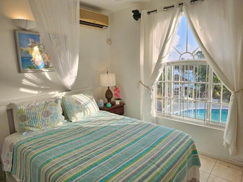 a bedroom with a bed and a large window at Blue Topaz in Ocho Rios
