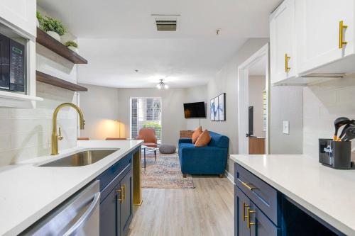 a kitchen with a sink and a living room at Modern Urban Oasis in Prime Buckhead Atlanta in Atlanta